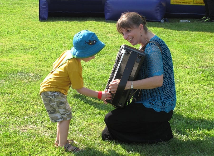 Donna Rhodenizer with accordion and young child